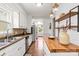 This well-lit kitchen features hardwood floors, white cabinets, stainless steel appliances and an island at 1512 Anthony Dr, Gastonia, NC 28052