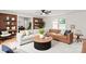 Open-concept living room featuring a brick wall, modern furniture, and beautiful hardwood floors throughout at 1512 Anthony Dr, Gastonia, NC 28052