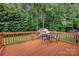 A wooden deck area with a table and chairs, perfect for outdoor dining and relaxing in the backyard at 16013 Wynfield Creek Pkwy, Huntersville, NC 28078