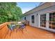 A wooden deck area with a table and chairs, perfect for outdoor dining and relaxing next to the house at 16013 Wynfield Creek Pkwy, Huntersville, NC 28078
