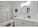 This bathroom features a shower with glass doors, a round mirror, and white cabinets with plenty of storage at 16013 Wynfield Creek Pkwy, Huntersville, NC 28078