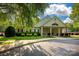 Charming clubhouse with welcoming porch, surrounded by lush landscaping and a beautiful neighborhood entrance at 16013 Wynfield Creek Pkwy, Huntersville, NC 28078