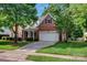 Traditional brick home with well-manicured lawn, white garage door, and charming front porch at 16013 Wynfield Creek Pkwy, Huntersville, NC 28078