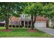 Charming brick home featuring a well-manicured lawn and mature trees in a desirable neighborhood at 16013 Wynfield Creek Pkwy, Huntersville, NC 28078