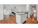 Open-concept living room and kitchen featuring an island and hardwood flooring at 16013 Wynfield Creek Pkwy, Huntersville, NC 28078