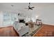 Cozy living room featuring a fireplace, large windows, and a ceiling fan at 16013 Wynfield Creek Pkwy, Huntersville, NC 28078