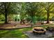 A vibrant playground featuring slides, swings, and picnic tables, nestled in a wooded area at 16013 Wynfield Creek Pkwy, Huntersville, NC 28078