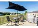 Back deck with a patio set and umbrella, perfect for outdoor dining and relaxation with a grill at 17438 Purser Dr, Locust, NC 28097
