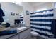 Bright bathroom with a white vanity, granite countertop, striped shower curtain, and nautical decor at 17438 Purser Dr, Locust, NC 28097