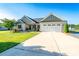 Charming single-story home with a manicured lawn, a two-car garage, and a welcoming front porch at 17438 Purser Dr, Locust, NC 28097