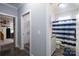 Hallway view of a bathroom with blue striped curtain and a peek into another room at 17438 Purser Dr, Locust, NC 28097