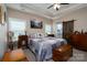 Comfortable main bedroom with tray ceiling, en suite bathroom, and natural light at 17438 Purser Dr, Locust, NC 28097