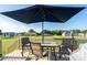 Outdoor patio with a dining table, seating, large umbrella, and views of the expansive backyard at 17438 Purser Dr, Locust, NC 28097