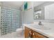 Well-lit bathroom with a stylish vanity, a decorative mirror, and a colorful shower curtain at 1912 Baxter St, Charlotte, NC 28204