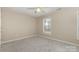 Neutrally decorated bedroom with a ceiling fan, features a bright window, and neutral carpet flooring at 1912 Baxter St, Charlotte, NC 28204