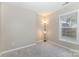 Neutral bedroom featuring a large window offering natural light, complemented by a floor lamp for added ambiance at 1912 Baxter St, Charlotte, NC 28204