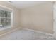 An empty bedroom featuring neutral colored walls, a window, and light gray carpet at 1912 Baxter St, Charlotte, NC 28204