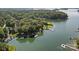 Picturesque aerial view of a lakeside property surrounded by lush greenery, private docks, and lake access at 19506 Mary Ardrey Cir, Cornelius, NC 28031