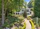 Expansive backyard featuring lush greenery, a stone patio, and a manicured garden at 19506 Mary Ardrey Cir, Cornelius, NC 28031