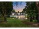 Beautiful brick home featuring mature trees, manicured lawn, and inviting front entrance at 19506 Mary Ardrey Cir, Cornelius, NC 28031