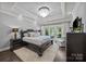 This bedroom features a large bed, elegant chandelier, and access to a balcony, perfect for enjoying lake views at 19506 Mary Ardrey Cir, Cornelius, NC 28031