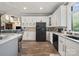 Modern kitchen featuring white cabinets, black appliances, and wood-look tile floors at 2769 Independence Way, Gastonia, NC 28056