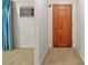 Inviting hallway featuring a hardwood door, neutral carpet, and a cooling AC unit for added comfort at 2831 Puetts Chapel Rd, Bessemer City, NC 28016