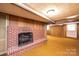 Basement with brick fireplace, wood-paneled walls, and a textured carpet at 2836 20Th Street Ne Ln, Hickory, NC 28601
