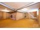 Basement features carpet, brick fireplace, wood paneling, and access to stairs at 2836 20Th Street Ne Ln, Hickory, NC 28601