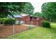 A charming single-story brick home featuring a covered entryway and a fenced yard with mature trees at 2836 20Th Street Ne Ln, Hickory, NC 28601