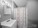 Cozy bathroom featuring a single sink vanity and a shower with a decorative curtain at 3509 Flint Dr, Statesville, NC 28677