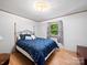 Neat bedroom with wood floors, a navy bed set, and a window for natural light at 3509 Flint Dr, Statesville, NC 28677