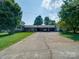 Spacious driveway leading to a charming home with lush landscaping and a welcoming entrance at 3509 Flint Dr, Statesville, NC 28677