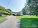 Spacious home with long driveway and large front yard, ample parking, and surrounded by mature trees at 3509 Flint Dr, Statesville, NC 28677