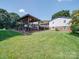 Backyard gazebo with outdoor seating, potted plants, and grill, perfect for al fresco dining and relaxation at 3509 Flint Dr, Statesville, NC 28677