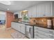 Well-lit kitchen featuring stainless steel appliances, white cabinets, and a tile backsplash at 3509 Flint Dr, Statesville, NC 28677