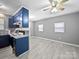 Kitchen/dining area with grey walls, laminate flooring, and blue cabinets at 3509 Flint Dr, Statesville, NC 28677