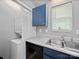 Convenient kitchen area featuring blue cabinets, a double basin sink and a washer/dryer at 3509 Flint Dr, Statesville, NC 28677
