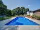 A full in-ground pool featuring concrete trim and a metal railing at 3509 Flint Dr, Statesville, NC 28677