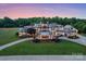 Stunning luxury home featuring manicured lawn, circular driveway, and impeccable landscaping at 355 Pelham Ln, Mooresville, NC 28115