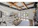 Expansive living room with exposed ceiling beams, a large sectional sofa, and multiple French doors to the backyard at 355 Pelham Ln, Mooresville, NC 28115