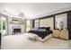 This primary bedroom boasts a fireplace, chandelier, large windows, and a neutral palette at 355 Pelham Ln, Mooresville, NC 28115
