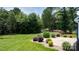 A backyard with manicured lawn, rock landscaping, and privacy provided by a tree line at 3622 46Th Ne Ave, Hickory, NC 28601