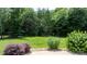 Lush backyard with manicured lawn, mature trees, and rock landscaping around a patio at 3622 46Th Ne Ave, Hickory, NC 28601