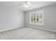 This bedroom has neutral carpet, bright light, and a large window with blinds at 3622 46Th Ne Ave, Hickory, NC 28601