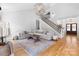 Spacious living room with hardwood floors, modern lighting, a cozy seating area, and an adjacent staircase at 3622 46Th Ne Ave, Hickory, NC 28601