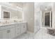 Elegant bathroom featuring double vanity, illuminated mirror, glass shower and walk-in closet at 4015 Randolph Rd, Charlotte, NC 28211