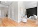 Bright hallway featuring hardwood floors, white trim, and a glimpse into a stylishly decorated living area at 4015 Randolph Rd, Charlotte, NC 28211