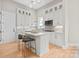 Modern kitchen with white cabinets, gold hardware, an island with seating, and stainless steel appliances at 4015 Randolph Rd, Charlotte, NC 28211