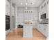 Modern kitchen with white cabinets, gold hardware, an island with seating, and stainless steel appliances at 4015 Randolph Rd, Charlotte, NC 28211